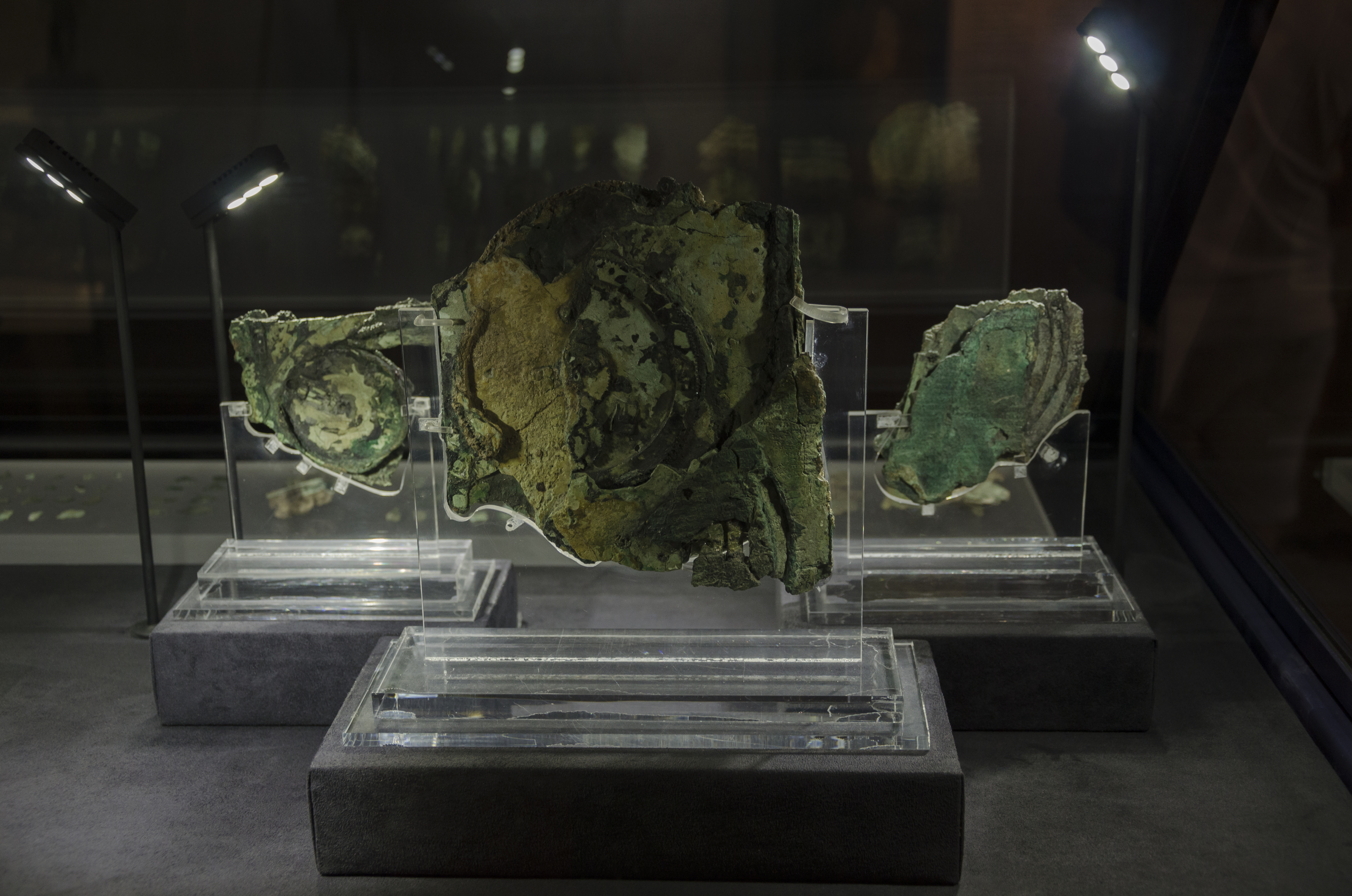 The Antikythera mechanism with visible bronze gears and circular dials.